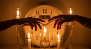 Deux mains se rejoignant à 18h18 signification flamme jumelle avec horloge et bougies dorées