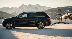 SUV avec porte ski attelage monté à l'arrière dans un parking de montagne enneigé